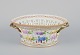 L'Art 
præsenterer: 
Royal 
Copenhagen 
Flora Danica 
frugtskål af 
porcelæn, 
dekoreret i 
farver og guld 
med blomster.