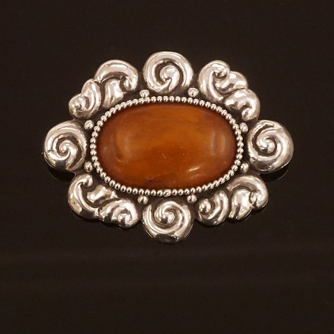 A large amber mounted silver brooch. Stamped by 
Thorvald Bindesbøll and Holger Kyster, Denmark. 
Size: 6,5x5cm