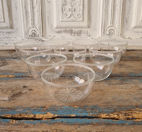 Set on 10 rinsing bowls in clear glass with belt sanding and sanded star at the 
bottom.