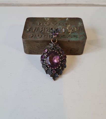 Antique medallion with beautiful purple glass stones set in patinated metal.