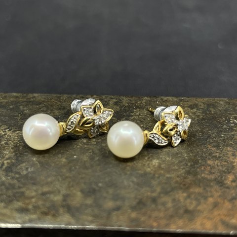 A pair of gold earrings with pearls