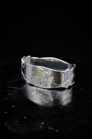 Old napkin ring in silver, stamped, with a motif of a boy riding a goat...