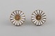 Georg Jensen earrings in gold-plated sterling silver with white enamel daisies. 
Late 20th century.
