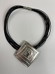 Large pendant in sterling silver / brooch in 14-row leather necklace with clasp 
made of metal (presumably steel)