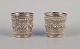 Chinese silversmith. Two small goblets richly decorated in relief with flowers 
and ornaments.