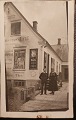 Ubrugt postkort: Butiksfacade fra 1920