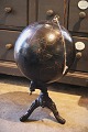 Dekorativ , 
antik globus i 
sort på jernfod 
til ...
