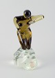 L'Art 
præsenterer: 
Cenedese, 
Murano, 
Italien.
Stor skulptur 
af kunstglas. 
Nøgen kvinde på 
klippe.