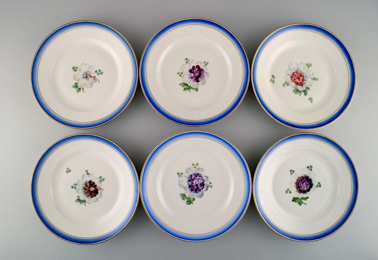 Six antique Royal Copenhagen plates in hand-painted porcelain with flowers and 
blue border with gold. Model number 592/9051. Late 19th century.
