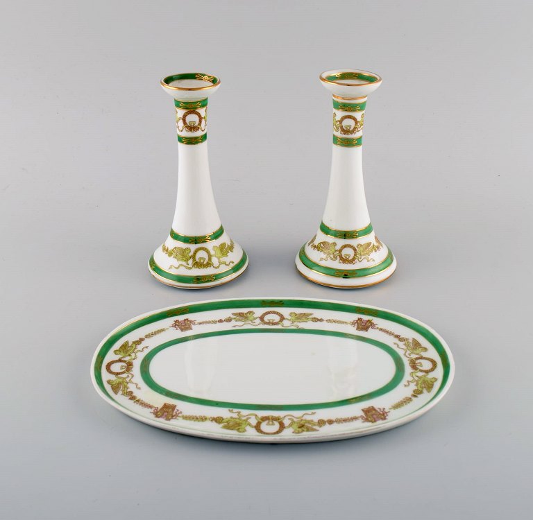 Limoges, France. Two candlesticks and a dish in hand-painted porcelain with 
green edge and gold decoration. 1930s / 40s.
