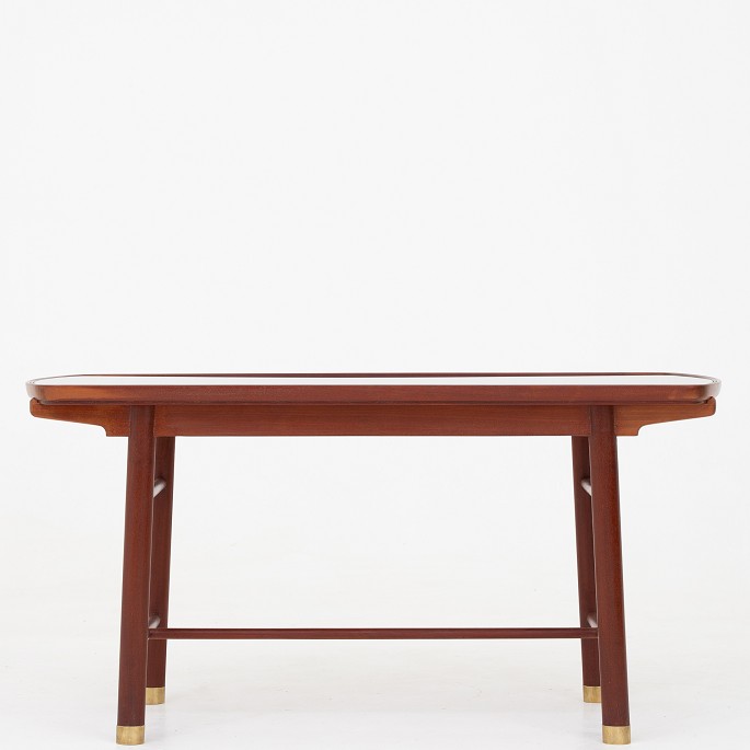 Peter Hvidt & Orla M. Nielsen / Ludvig Pontoppidan
Coffee table in solid Cuban mahogany and shoes in brass with top in black 
glass.
1 pc. in stock
Original condition
