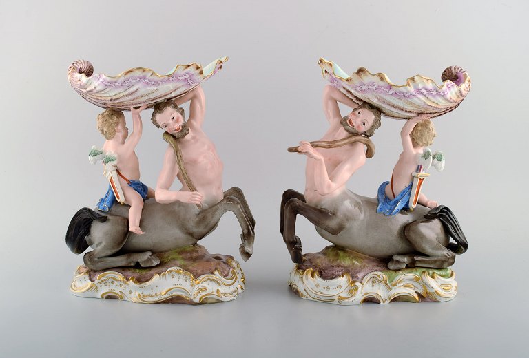 Et par antikke figurative Meissen opsatser i håndmalet porcelæn. Puti på kentaur 
bærende stor muslingeskal. Museumskvalitet. Dateret 1815-1860.
