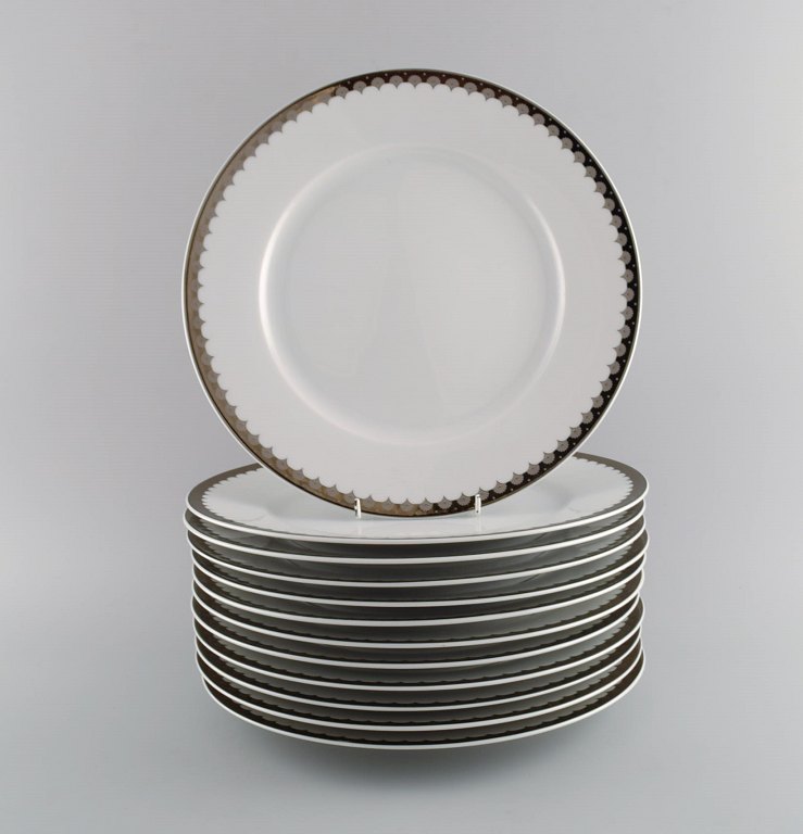 Sigvard Bernadotte for Christineholm. Tolv store middagstallerkener i porcelæn 
med sølvkant. 1980