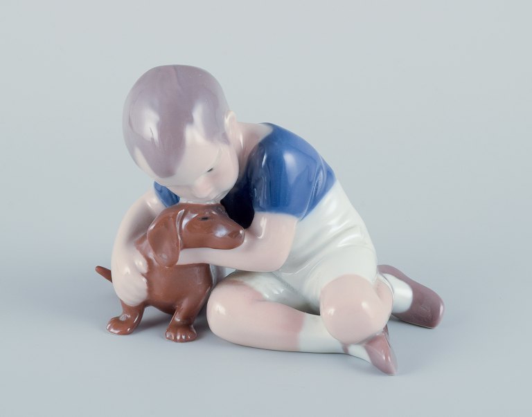 Ingeborg Plockross Irminger for Bing & Grøndahl, porcelænsfigur af dreng med 
gravhund.