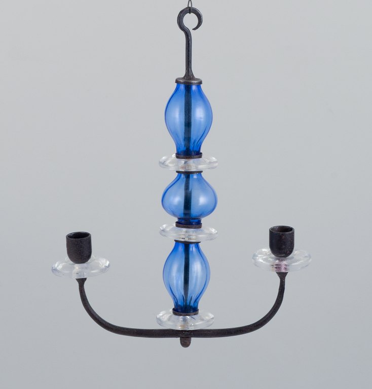 Erik Höglund (1932-1998) for Kosta Boda, Sweden. Rare two-armed hanging candle 
holder in cast iron and mouth-blown art glass.