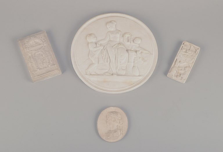 Four plaster reliefs. Large round plaque with Bertel Thorvaldsen motif, 
religious motif, and a woman in profile.