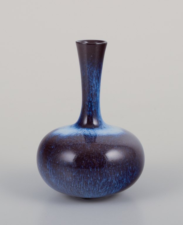 Gunnar Nylund (1904-1997) for Rörstrand, Sverige.
Miniaturevase med slank hals. Glasur i blålige og violette nuancer.