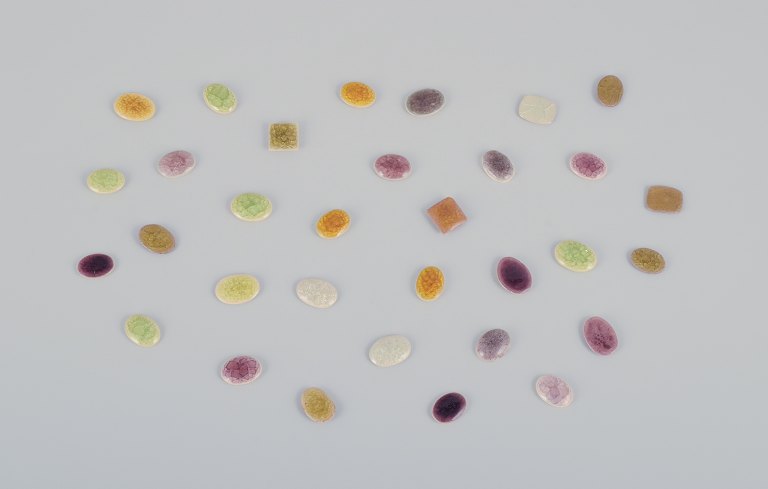 Ole Bjørn Krüger (1922-2007), Danish sculptor and ceramicist.32 unique brooches in glazed stoneware in purple, white, yellow, and green shades.