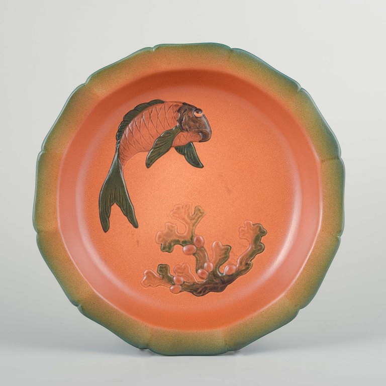 Ipsens Enke, Denmark
Large ceramic wall plaque/decorative dish with relief decoration of fish and 
coral. Orange glaze with a soft green rim.